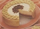 Une part de flan fondant au chocolat noir avec des rondelles de bananes fraîches disposées sur le dessus.